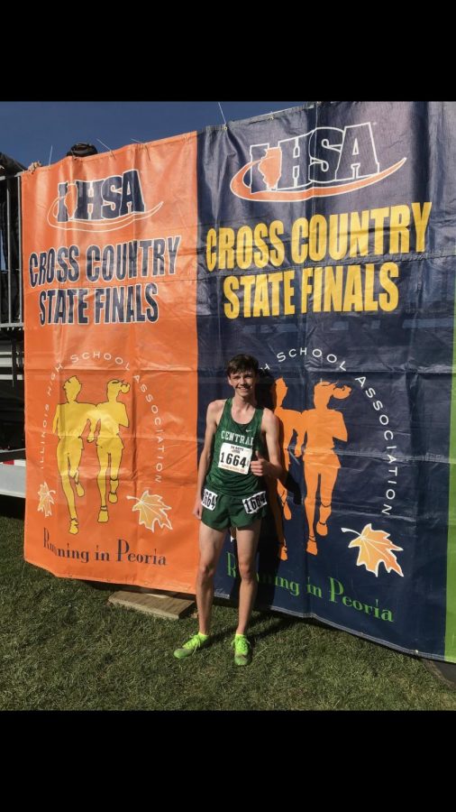 Craig Hundley smiles at the cross country state final banner.