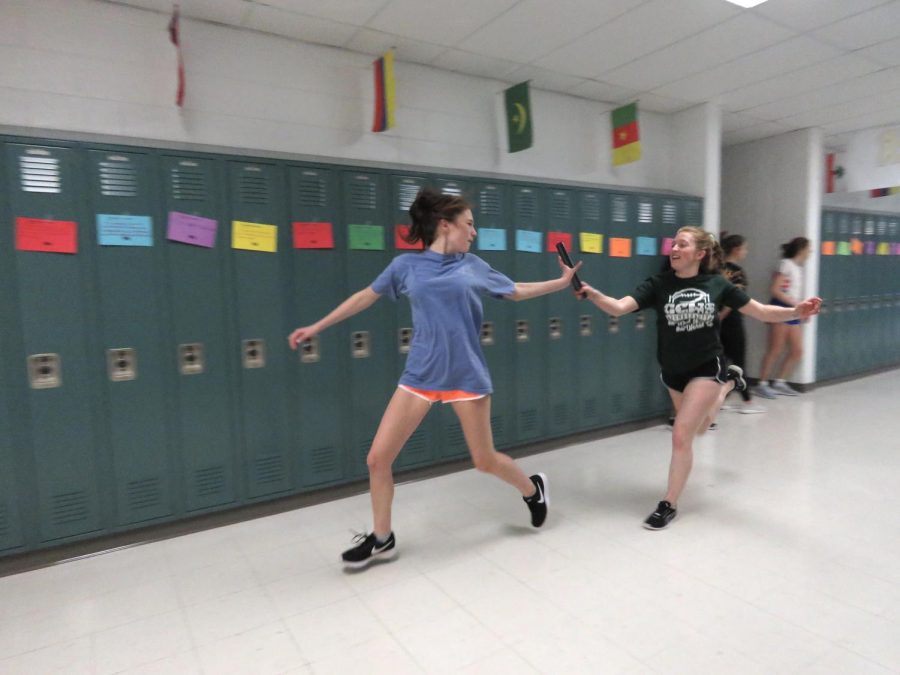 Freshman Yasmine Khalaf grabs the baton from sophomore Ashlyn Duffee during practice.