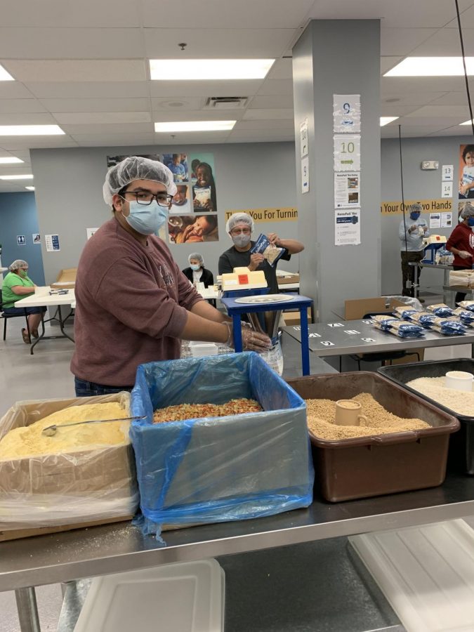 Senior Luis Martinez  is volunteering at Feed My Starving Children with masks and social distancing.
