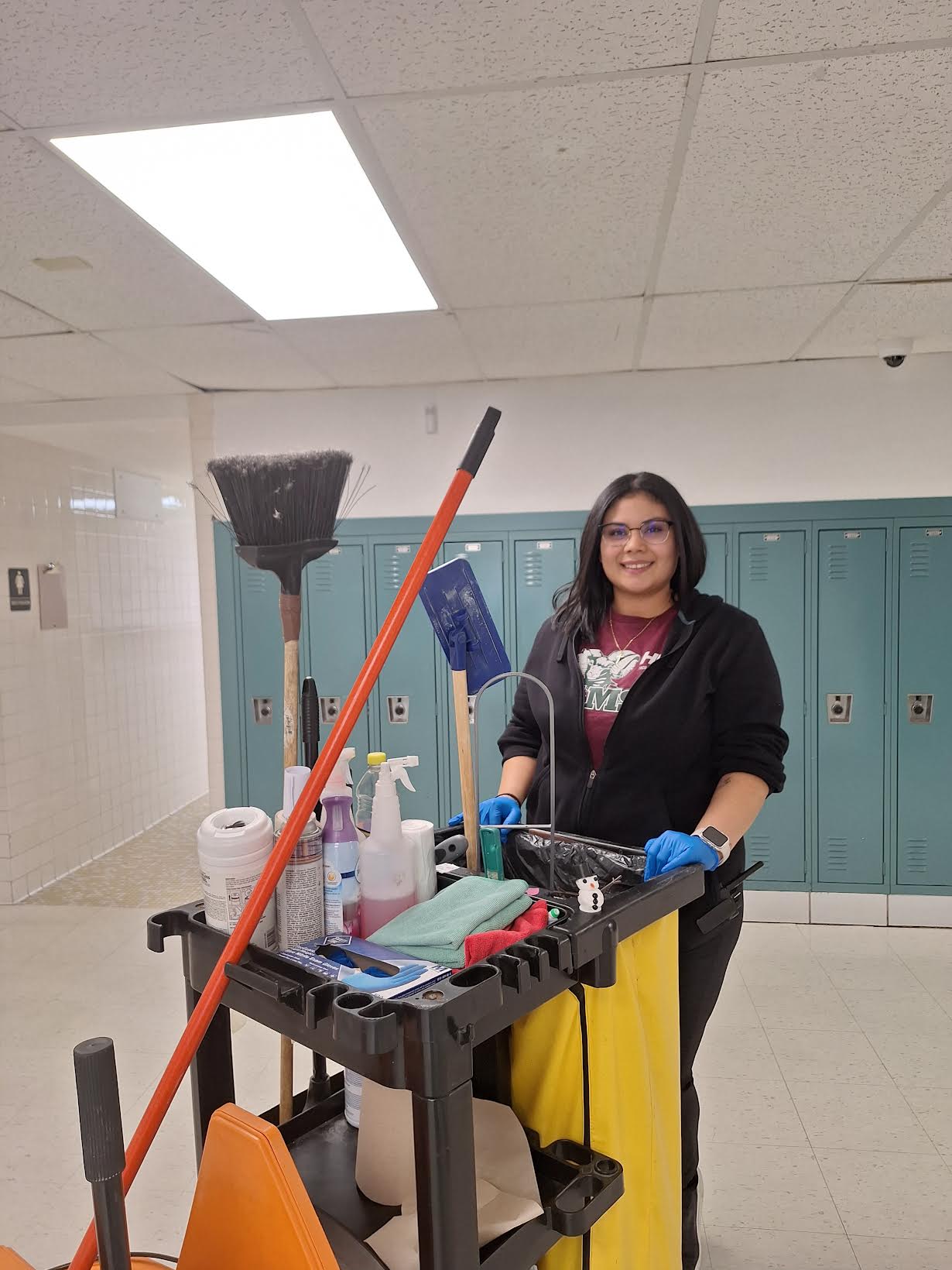 Sofia uses her cart to help clean around the school.