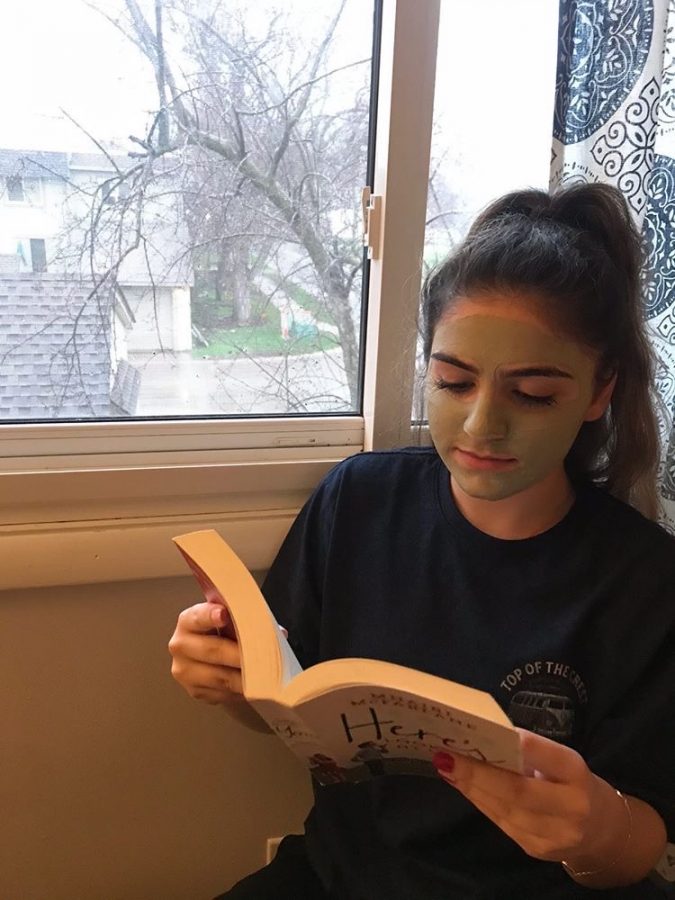 Staff reporter Maia AlBarrak enjoys her favorite book while waiting for her clay mask to dry.