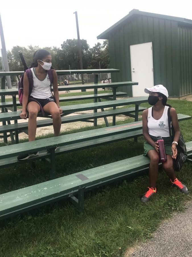 Thanya Sriselvakumar and Sudiksha Peramanu have a conversation after a tennis match, wearing face masks to keep each other safe. (Photo by Maia AlBarrak)