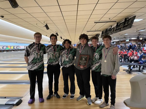 Grayslake Central Varsity team shows off their medals and plaque after a tournament