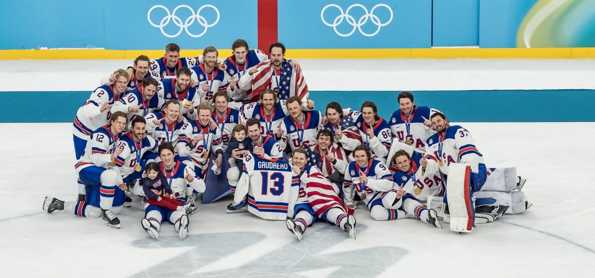 The U.S. Men's Hockey Team celebrating on the ice with their gold medals, while remembering their teammate Johnny Gaudreau. Photo purchased from Shuttershock. 